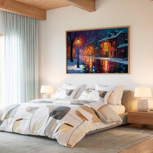 May include: A rectangular wall art print featuring an oil painting of a snowy street at night, illuminated by a glowing streetlamp. The scene depicts warm orange light reflecting on a wet, dark road, with buildings and trees under a deep purple sky.