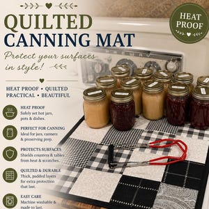 May include: A quilted canning mat featuring a black and white checkered and patterned design. The mat is topped with several glass jars filled with preserves and a red metal jar lifter. Text on the image includes QUILTED CANNING MAT and HEAT PROOF.