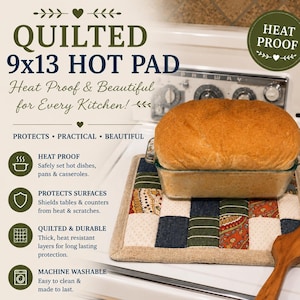 May include: A square quilted hot pad featuring a patchwork design of cream, navy blue, and olive green fabric squares with paisley and striped patterns. A glass loaf pan containing a loaf of bread sits on the pad next to a wooden utensil.