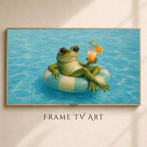 May include: A framed print featuring a green frog wearing sunglasses, relaxing in a blue and white striped inflatable ring in a pool. The frog holds a cocktail with an orange slice and a small umbrella. The text "FRAME TV ART" is at the bottom.