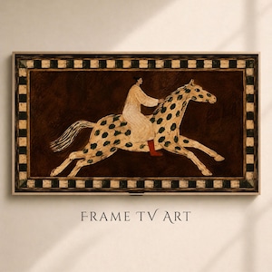 Op de afbeelding: Een rechthoekig wandkunstwerk voor een televisielijst met een schilderij van een persoon in een wit gewaad op een gevlekt paard. Het paard heeft groene vlekken op een crèmekleurig lichaam en is omgeven door een zwart-wit geblokte rand.