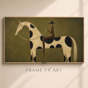 May include: A rectangular wall art piece featuring a stylized painting of a person in a dark hat and brown clothing riding a cream-colored horse with large black spots. The horse has a long white mane and tail, set against a solid olive green background.