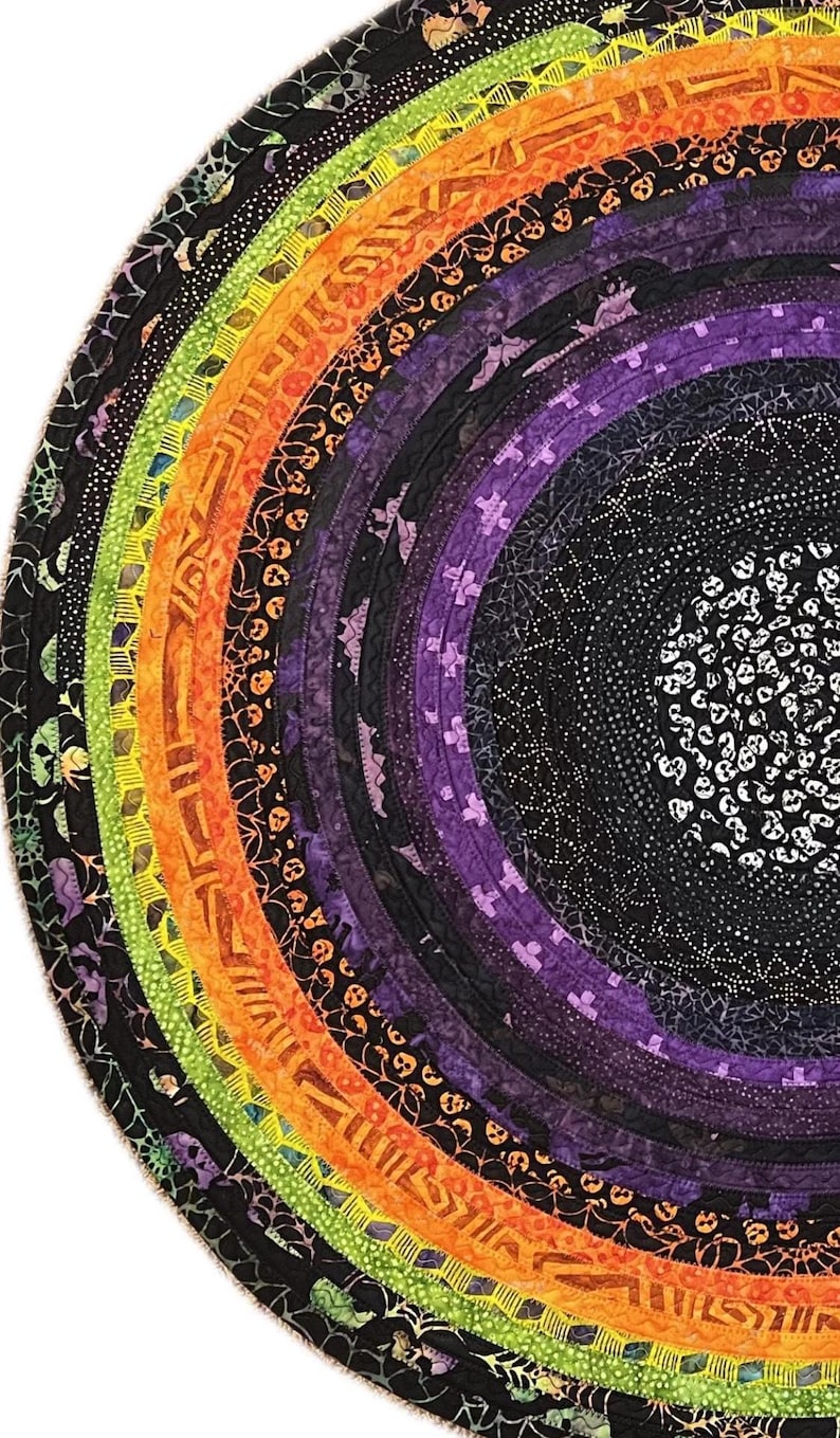 May include: Circular Halloween-themed quilt with concentric rings of fabric in a rainbow of colors. The quilt features patterns of bats, spiders, skulls, and other spooky motifs. The design is a vibrant and festive decoration for the Halloween season.