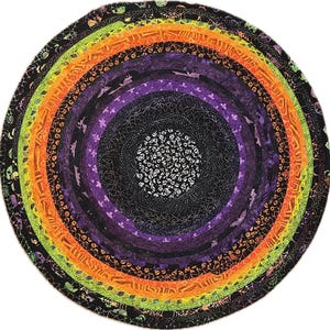 May include: A circular Halloween-themed rug with concentric rings of color. The rug features black, purple, orange, and green bands, with patterns of bats, spiders, and skulls. The center has a white skull design.