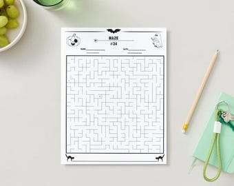 May include: A black and white Halloween-themed maze puzzle with the text "MAZE #34". The puzzle features a pumpkin, bat, and ghost illustrations. A pencil, green notebook, and keys are also visible.