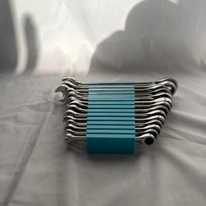 Könnte beinhalten: Ein Set aus zwölf silberfarbenen Metall-Ringmaulschlüsseln, die in einem Stapel angeordnet und von einem hellblauen Kunststoff-Organizer-Clip zusammengehalten werden. Jeder Schlüssel hat ein offenes Ende und eine Ratschenringseite.