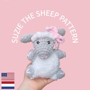 Op de afbeelding: Een gehaakt pluche schaap van grijs en wit garen, met een roze strik op het hoofd en roze gestikte details op de pootjes. De tekst SUZIE THE SHEEP PATTERN staat in een boog boven het schaap, met een klein icoon van een Amerikaanse vlag.
