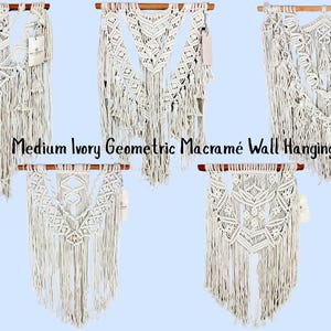 May include: Five ivory macramé wall hangings with geometric knot patterns, each suspended from a horizontal wooden dowel. The pieces feature intricate woven designs and long, loose fringe at the bottom. Text reads: Medium Ivory Geometric Macramé Wall Hanging.