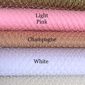 May include: Five different colors of tulle fabric, from top to bottom: gold metallic, light pink, champagne, white, and ivory.