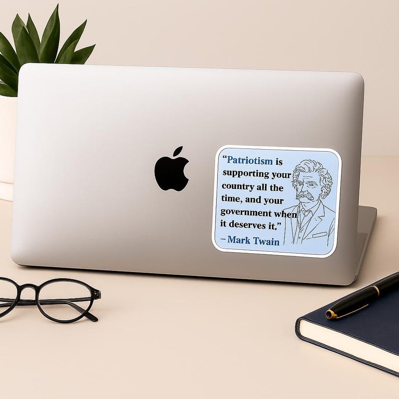 May include: A laptop with a sticker featuring a Mark Twain quote: "Patriotism is supporting your country all the time, and your government when it deserves it." The sticker has a blue border and a portrait of Mark Twain.