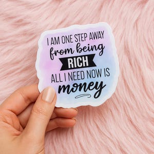 May include: A white sticker with a watercolor background in shades of purple, blue, and pink. The sticker has the text "I AM ONE STEP AWAY from being RICH ALL I NEED NOW IS money" in black script.