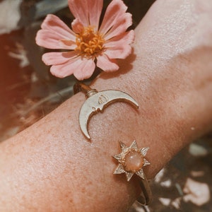 Luminoso. Un brazalete ajustable de latón con forma de sol y luna de piedra solar celestial estilo bohemio.