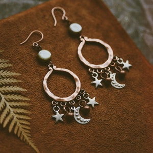 Celestial beauties made from antiqued copper and silver charms, glass beads and simple copper earwires. They measure approximately 2.5” long.