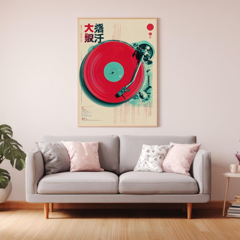 Op de afbeelding: Een ingelijste poster met een vintage platenspeler, een rode plaat en turquoise accenten. De poster heeft Japanse tekst en een rood cirkelontwerp. Het hangt boven een grijze bank met kussens.