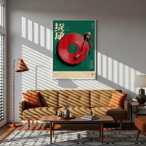May include: A framed wall poster featuring a top-down view of a red vinyl record on a turntable against a dark green background. The poster includes white text in a stylized font and a cream-colored bottom border with small red square accents.
