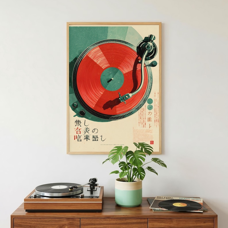 May include: A rectangular wall poster featuring a graphic illustration of a turntable with a vibrant red vinyl record. The design includes dark teal accents and Japanese text characters. Below the poster sits a wooden record player and a plant.