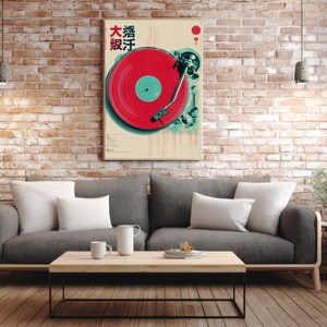 Op de afbeelding: Een ingelijste poster met een vintage platenspelerontwerp, met een rode plaat en turquoise accenten. Japanse karakters zijn zichtbaar. De poster hangt aan een bakstenen muur boven een grijze bank en een houten salontafel.