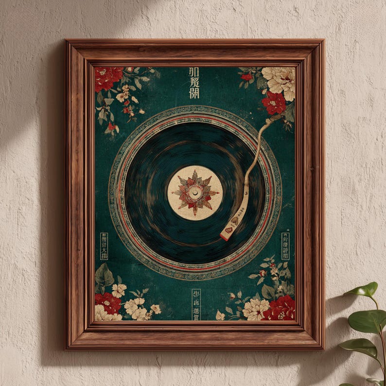 May include: A framed art print featuring a vintage-style illustration of a record player. The artwork has a teal background with floral accents in red and white. The record player's needle is positioned over the record. The frame is made of brown wood.