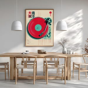 Op de afbeelding: Een ingelijste kunstdruk met een rode vinylplaat op een platenspeler. Het kunstwerk heeft een vintage esthetiek met Japanse tekst en een rood-teal kleurenschema. De print wordt weergegeven boven een houten eettafel met bijpassende stoelen.