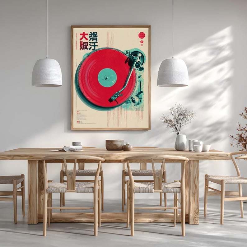 Op de afbeelding: Een ingelijste kunstdruk met een rode vinylplaat op een platenspeler. Het kunstwerk heeft een vintage esthetiek met Japanse tekst en een rood-teal kleurenschema. De print wordt weergegeven boven een houten eettafel met bijpassende stoelen.