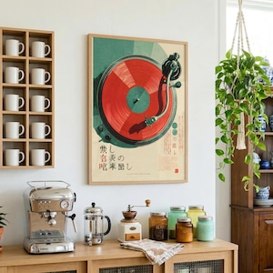 May include: A rectangular wall poster featuring a graphic illustration of a red vinyl record on a turntable with Japanese text. The poster is displayed on a white wall next to a wooden shelf containing ten white mugs and a hanging green plant.