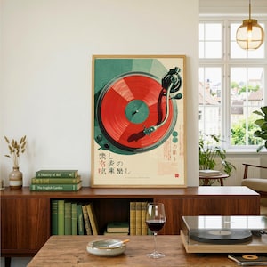 May include: A rectangular wall art print featuring a top-down illustration of a record player with a vibrant red vinyl record. The design includes Japanese text characters and a teal circular background element, presented in a light-colored wooden frame.