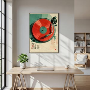 May include: A framed wall art print featuring a top-down illustration of a turntable with a vibrant red vinyl record. The background is a cream color with geometric green accents and Japanese text characters printed in black and red ink.