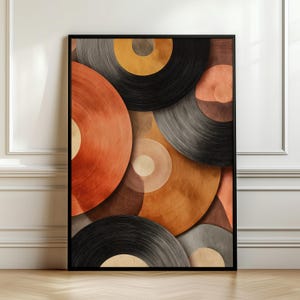Op de afbeelding: Een rechthoekige wandkunstprint met een abstracte compositie van overlappende cirkelvormige figuren in tinten zwart, antracietgrijs, gebrand oranje en beige. Het ontwerp toont concentrische lijntexturen binnen elke cirkel.