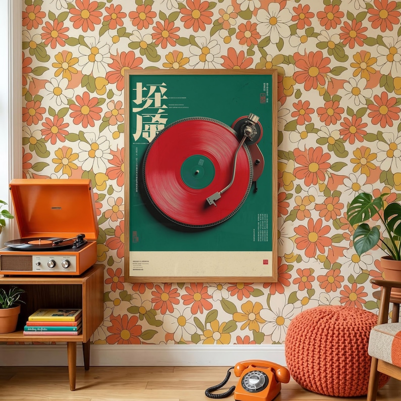 May include: A framed vertical poster featuring a red vinyl record on a turntable against a dark green background, displayed on a wall with a retro orange, yellow, and white floral pattern. The poster includes stylized text and a small red square.