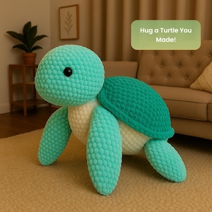May include: A large, handmade turquoise turtle plush toy with a textured shell and limbs. The turtle has a cream-colored underside and a black eye. The text "Hug a Turtle You Made!" is in a green rectangle.