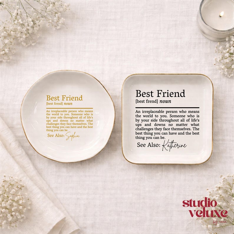 K&ouml;nnte beinhalten: Zwei wei&szlig;e Keramikschalen, eine rund und eine quadratisch, jeweils mit einer in Gold oder Schwarz gedruckten Definition eines besten Freundes. Der Text lautet: Best Friend [best frend] noun. An irreplaceable person who means the world to you.