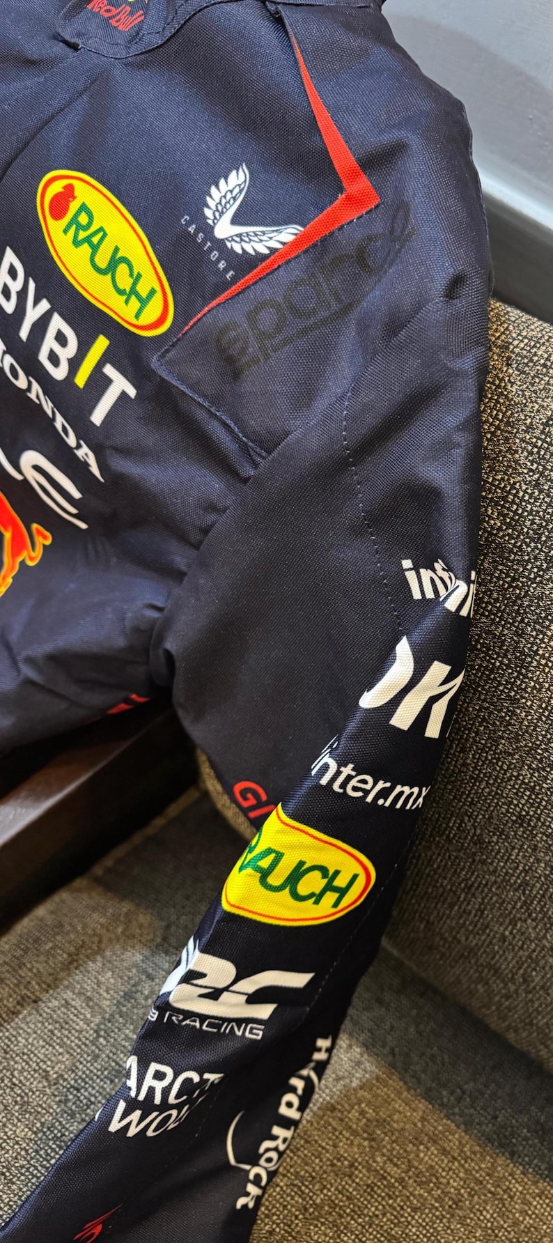 May include: Navy blue jacket with sponsor logos including "RAUCH", "BYBIT", and "HONDA". The jacket features red and white accents, and the "Castore" logo. The sleeve displays "inter.mx" and "Hard Rock" text.