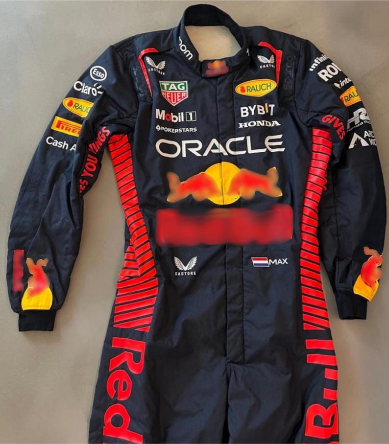May include: A dark navy racing suit with red and yellow detailing. The suit displays sponsor logos such as "Oracle," "Tag Heuer," and "Esso." The Red Bull logo is on the chest. The suit has long sleeves and a full-length design.