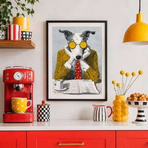 Op de afbeelding: Een ingelijste kunstdruk met een hond met een gele bril, een geel gestreepte blazer en een rode stropdas met stippen, die een krant leest. De print staat op een wit oppervlak met een rode espressomachine en een gele mok met stippen.