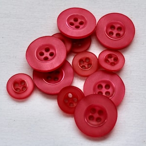 Rosa satinato faccia perla 4 pulsanti foro. 2 taglie disponibili- 3/4" (19mm) e 1/2" (12,6 mm) La dimensione del lotto è 6 pulsanti.