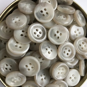 Jasnoszary guzik, szeroka lamówka, 4 otwory, płaski tył. Rozmiar 5/8" (15 mm) Guzik - Jasnoszary guzik do spodni Wyprodukowano we Włoszech - Wybierz ilość przy kasie.