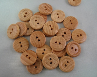 May include: A collection of light brown wooden buttons with two holes each. The buttons are round with a slightly textured surface, and the wood grain is visible. These buttons are suitable for sewing and craft projects.