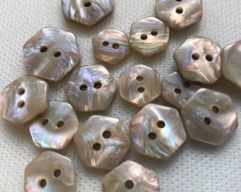 May include: A collection of iridescent, hexagonal buttons with two holes each. The buttons have a pearlescent sheen, reflecting a range of colors. These decorative buttons are ideal for sewing and craft projects.