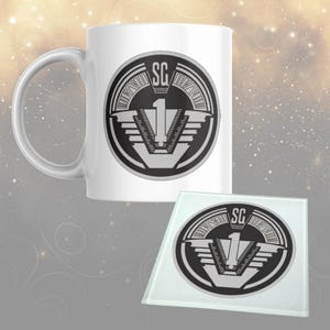 May include: White ceramic mug and glass coaster set. Both items display a black and grey emblem with the letters "SG" and the number "1". The design is circular with a stylized V-shaped element.