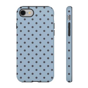 May include: A light blue phone case featuring a repeating pattern of dark grey polka dots. The case is shown from the front and side, highlighting the design and the phone's camera and buttons.