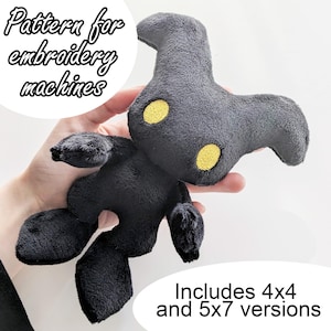 May include: Black plush toy with yellow eyes. The toy is shaped like a creature with large ears and a small body. The text "Pattern for embroidery machines" and "Includes 4x4 and 5x7 versions" is visible in the image.