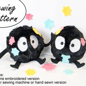 May include: Two plush, black, round creatures with large white eyes and felt star accents in pink, yellow, and blue. The creatures have black arms and legs. The image includes the text "Sewing Pattern".