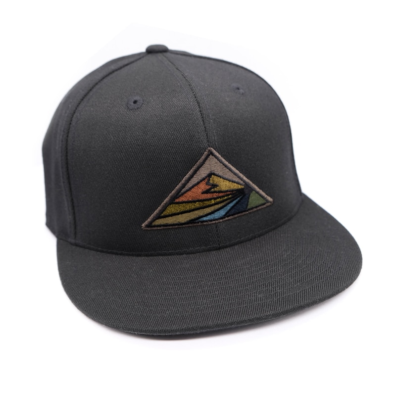 May include: Black fitted baseball cap with a colorful mountain scene embroidered on the front.