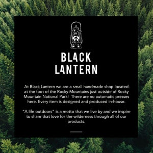 Logo image for Black Lantern Studio inset inside over an outline of tall pine trees viewed from above. The logo square contains white lettering on a black background. The words explain this is a small Colorado shop. A Life Outdoors is their motto.