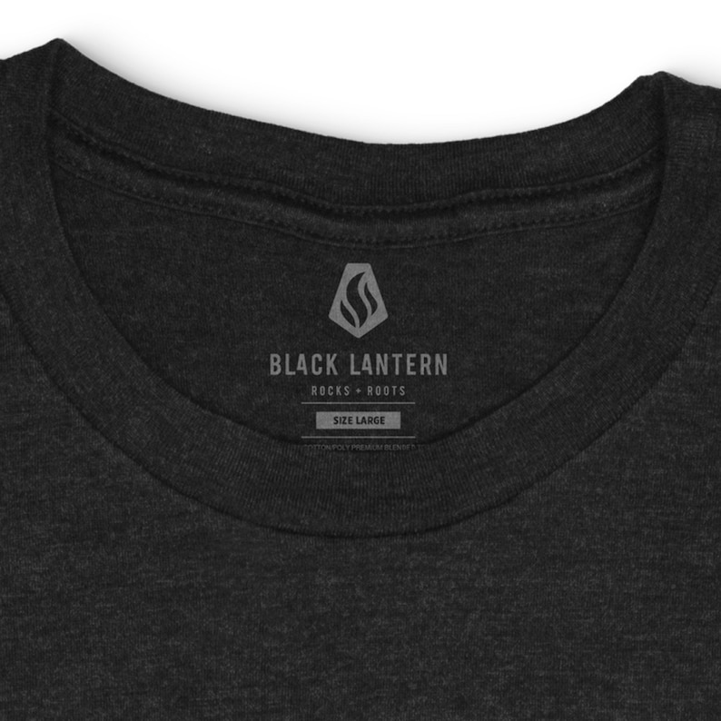 Closeup view of the inside neckline area of the t-shirt showing the Black Lantern Studio name and logo tag free label.