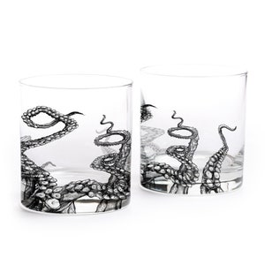 May include: Two clear glass tumblers with a black and white octopus tentacle design. The tentacles are wrapped around the glass and have a detailed, realistic look.