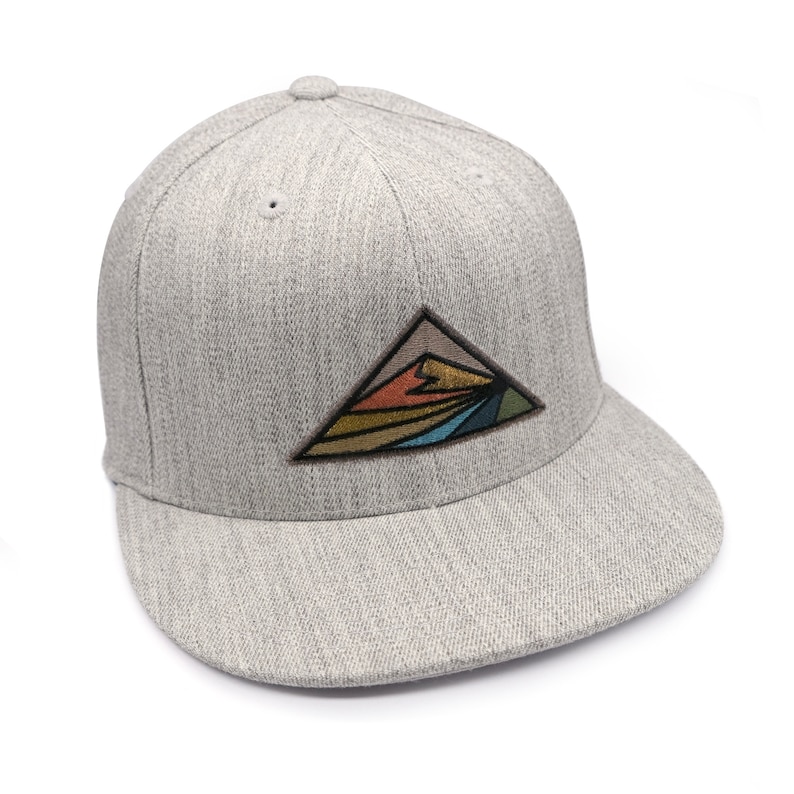 May include: A gray and white baseball cap with a colorful mountain scene embroidered on the front.