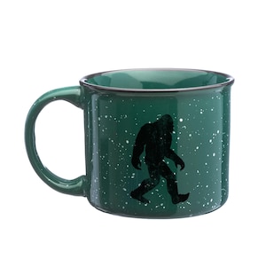 May include: A green camping mug with a white speckled design and a silhouette of Bigfoot walking on the front.