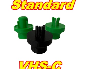 May include: Three plastic VHS-C and Standard video cassette adapters. Two are green, and one is black. The word "Standard" is in yellow text above the adapters, and "VHS-C" is in yellow text below.