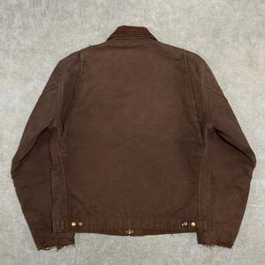 Puede incluir: Chaqueta de trabajo marr&oacute;n con cuello de pana. La chaqueta tiene cierre de botones, dos bolsillos delanteros y un dobladillo desgastado. Fabricada con un material duradero, es adecuada para actividades al aire libre.